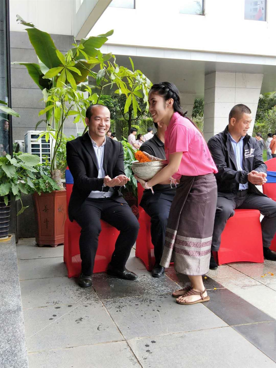 老撾駐廣西留學(xué)生代表將浸有花瓣的香水灑客人的手上，表示對嘉賓的美好祝福（圖一）
